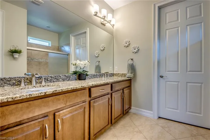 Bathroom with oversized vanity, double sink, and tile floors