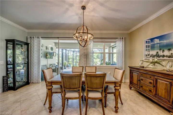 Dining area with a chandelier, ornamental molding, and light tile floors