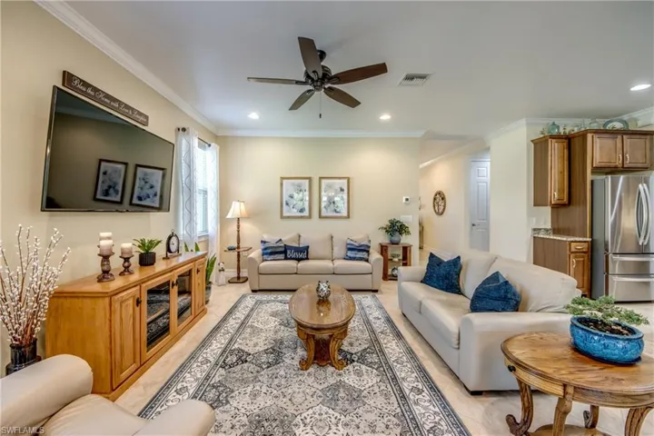 Living room featuring ceiling fan and ornamental molding
