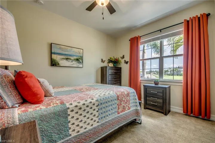 Carpeted bedroom featuring ceiling fan