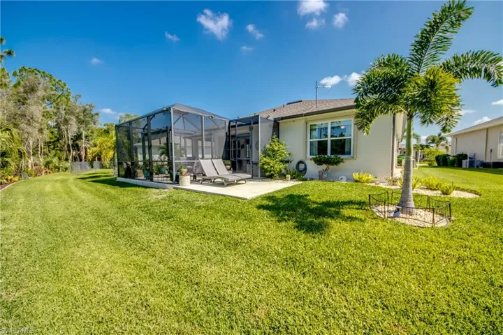 Back of house with a lawn, a lanai, and a patio