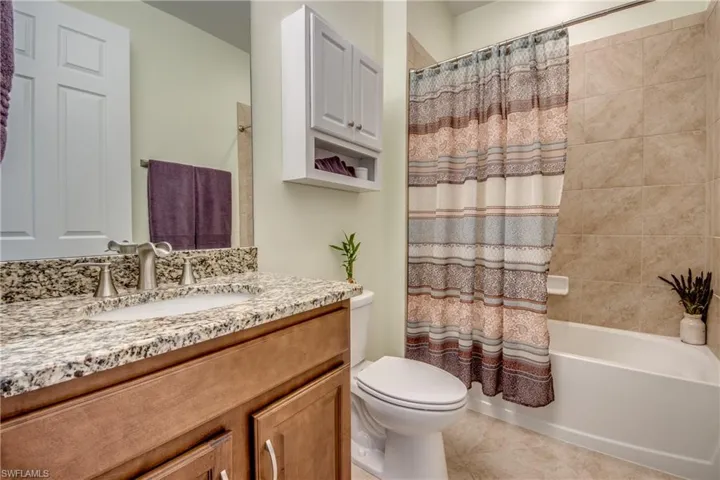Full bathroom featuring tile flooring, toilet, shower / tub combo, and oversized vanity