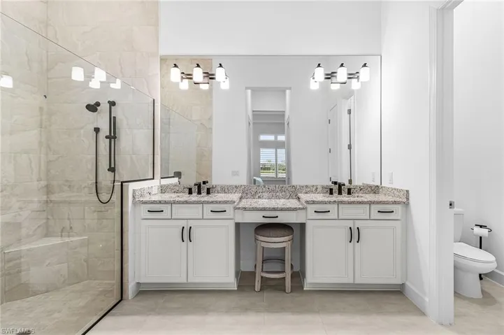 Full bathroom with walk in shower, vanity, and light tile patterned floors