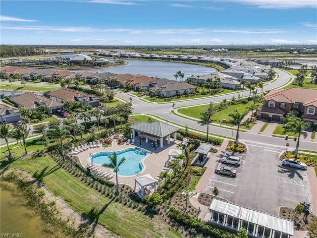 Aerial perspective of suburban area featuring a pool area and a large body of water