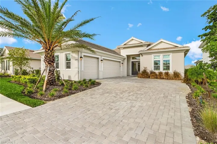 Ranch-style house with stucco siding, decorative driveway, and an attached garage