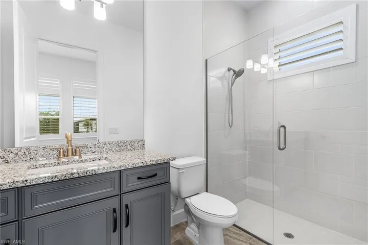 Bathroom featuring a shower stall and vanity