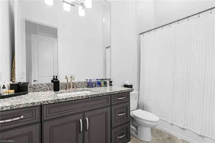 Full bath featuring vanity and shower / tub combo with curtain