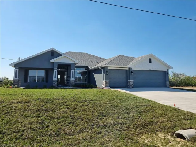 View of front of home featuring a garage and a front yard