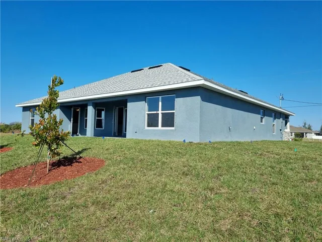 Back of house featuring a yard