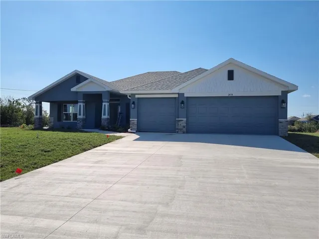 View of front of house with a garage and a front yard