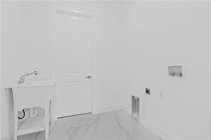 Laundry room with light marble finish flooring, hookup for a washing machine, and electric dryer hookup