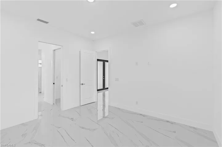 Unfurnished bedroom with recessed lighting and light marble finish floors