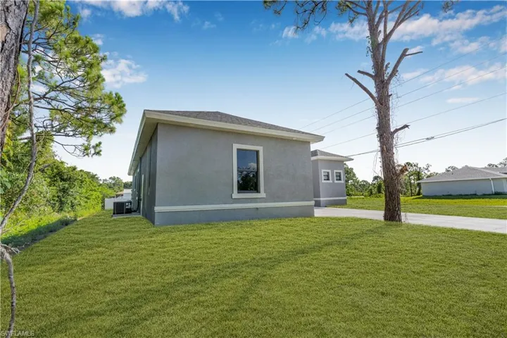 View of property exterior featuring a yard and stucco siding