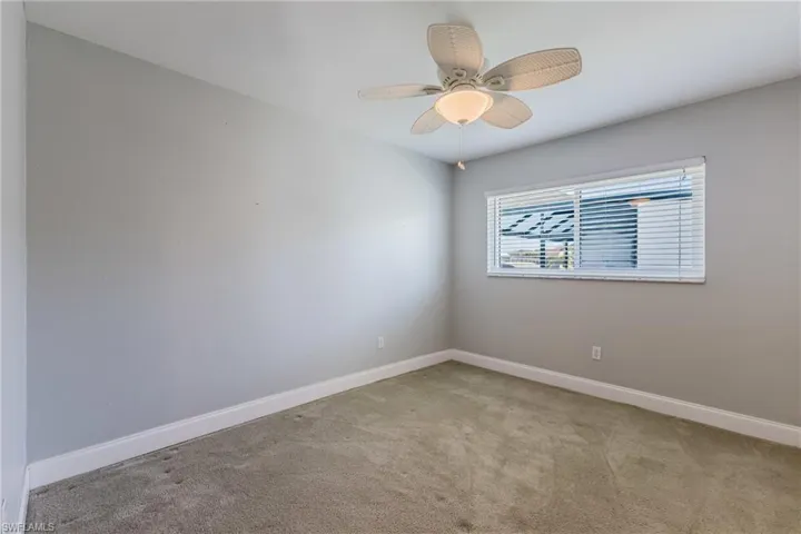 Spare room featuring light colored carpet and ceiling fan