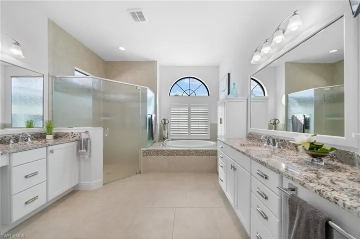 Primary bathroom with Separate Vanities,Replaced master shower enclosure with updated glass requiring no squeegee cleaning! New Storage Chest!