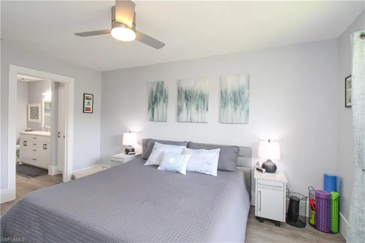 Bedroom featuring light hardwood / wood-style floors, connected bathroom, sink, and ceiling fan