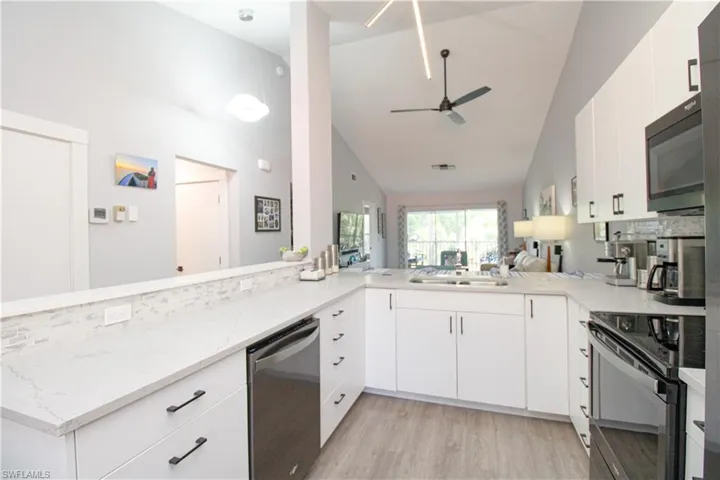 Kitchen with light hardwood / wood-style flooring, kitchen peninsula, dishwasher, ceiling fan, and range with electric stovetop