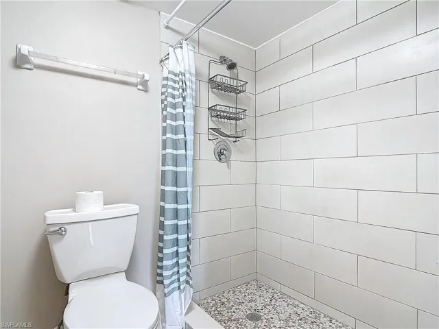 Bathroom with curtained shower and toilet