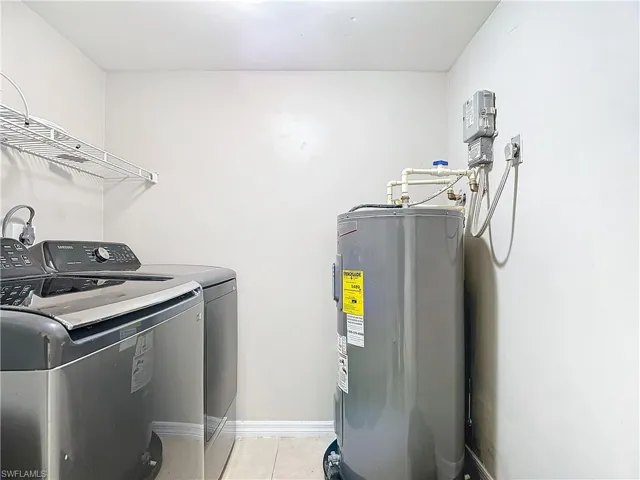 Laundry area, light tile patterned floors, and washer and dryer