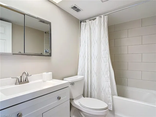 Full bathroom featuring toilet, vanity, and shower / bath combination with curtain