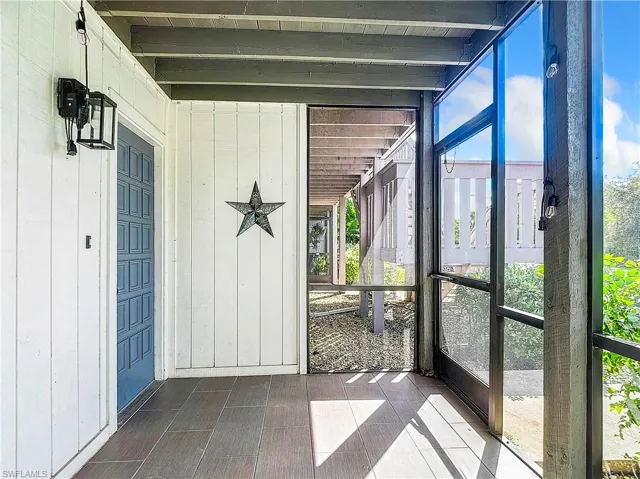 Unfurnished sunroom featuring beamed ceiling