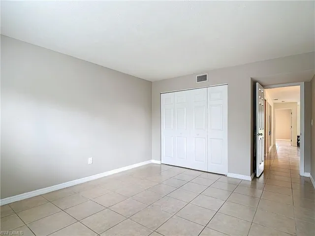 Unfurnished bedroom with a closet and light tile patterned floors