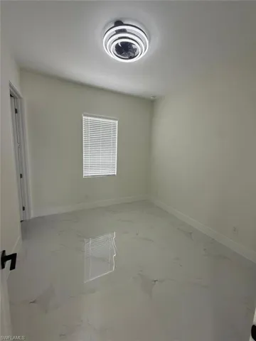Empty room featuring baseboards and light marble finish floors