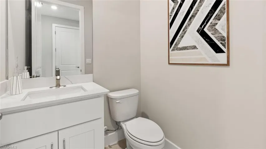 White vanity with a single basin sink, brushed nickel faucet, and integrated countertop
