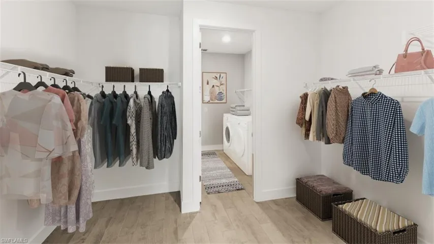 Walk-in closet featuring wire shelving, hanging rods, and wood-finish flooring