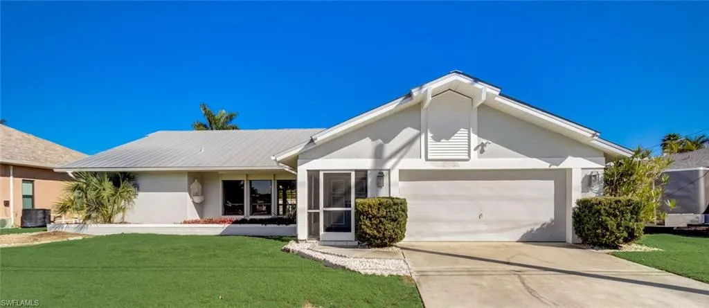 View of front of property with a front yard and a garage