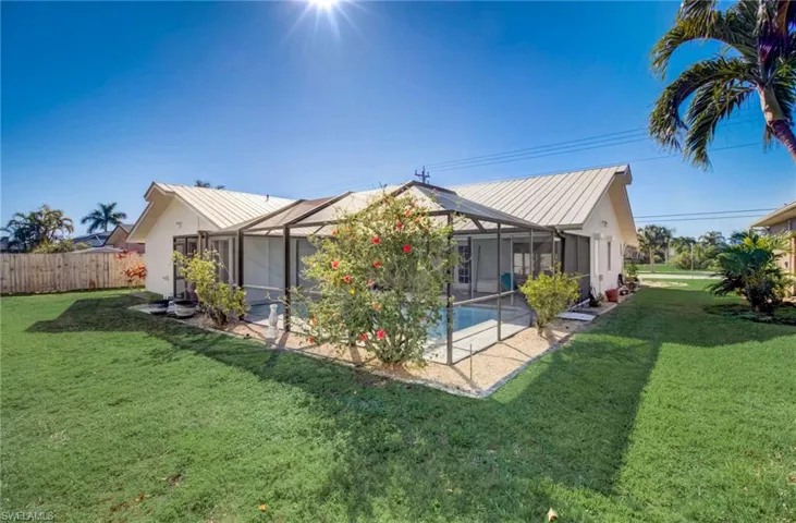 Back of house with a fenced in pool, glass enclosure, a yard, and a patio