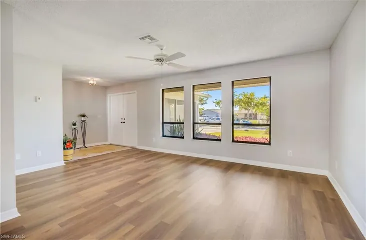 Spare room with hardwood / wood-style floors, ceiling fan, and a textured ceiling