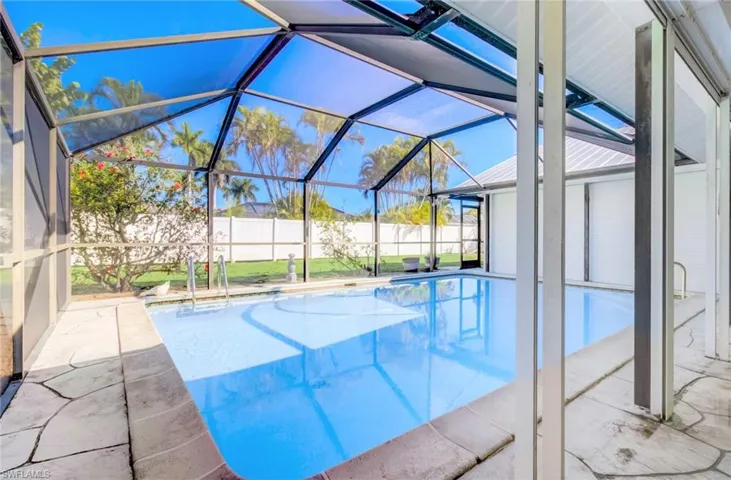 View of oversized swimming pool featuring a lanai and a patio around it.