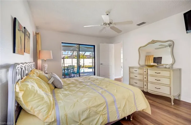 Bedroom featuring hardwood / wood-style flooring, a textured ceiling, access to outside, and ceiling fan