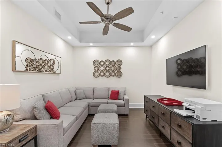 Den with recessed lighting, a tray ceiling, dark wood-style flooring, and ceiling fan