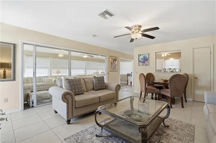 Living area with large sunroom in the background - Virtually Edited Image