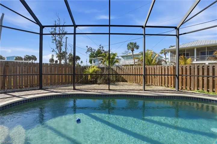 View of swimming pool with a fenced backyard - Virtually Edited Image