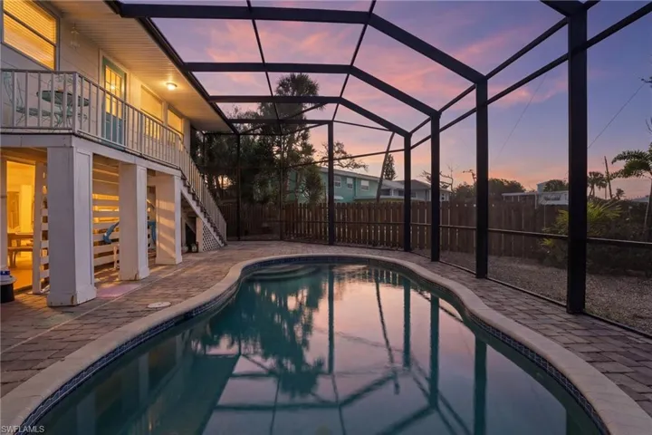 Pool at dusk with large screened in lanai and oversized private backyard - Virtually Edited Image