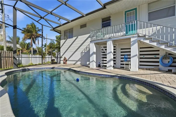 View of pool with large screened in lanai and a balcony - Virtually Edited Image