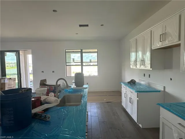 Kitchen with dark hardwood / wood-style floors, sink, and white cabinets