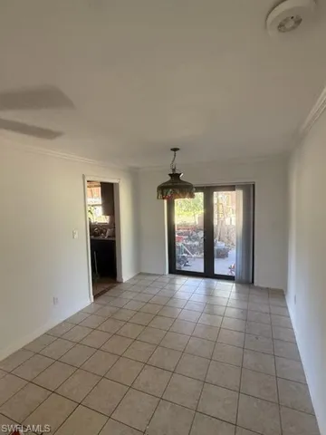 Unfurnished room with ornamental molding and light tile patterned floors