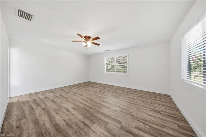 Empty room with light wood finished floors and a ceiling fan