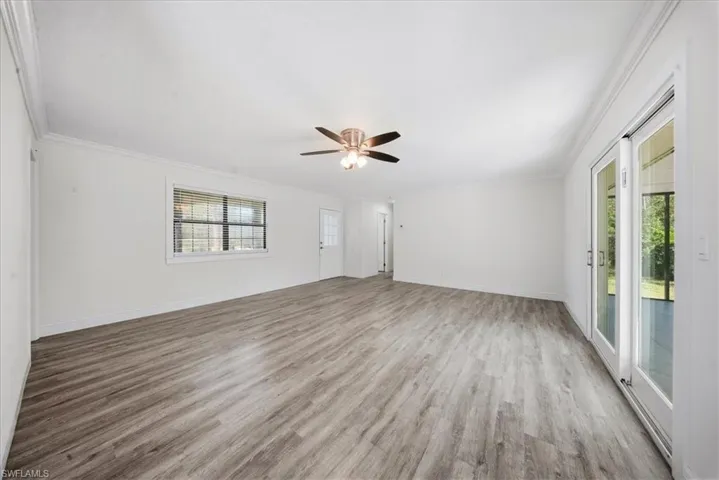 Unfurnished room with crown molding, light wood-type flooring, and ceiling fan