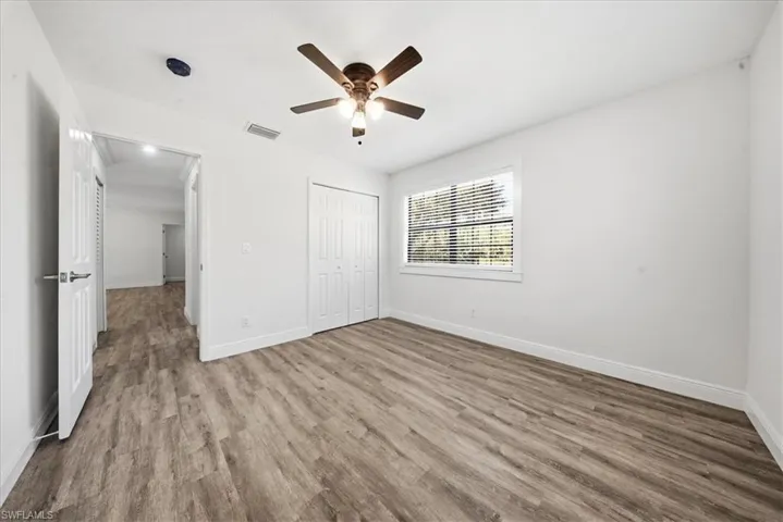 Unfurnished bedroom with wood finished floors, a ceiling fan, and a closet