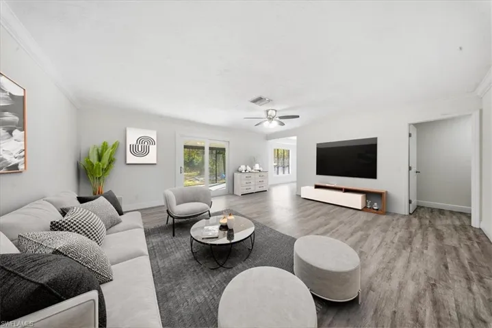 Living room featuring wood finished floors, ornamental molding, and a ceiling fan