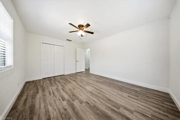 Unfurnished bedroom with a ceiling fan, wood finished floors, and a closet