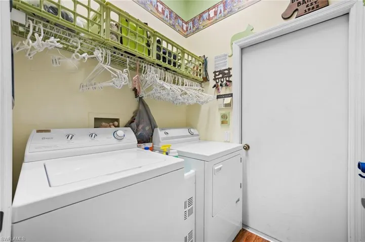 Laundry room with independent washer and dryer and light wood-style floors