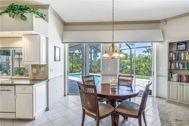 Breakfast area light tile flooring and crown molding view to pool and golf course