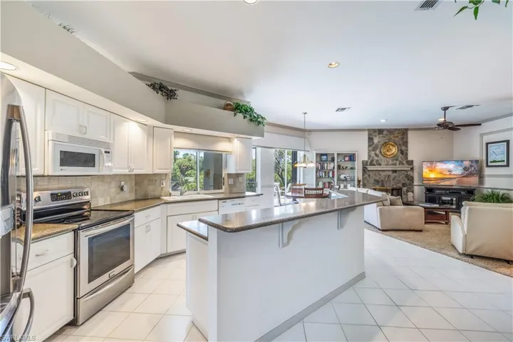 Kitchen - stainless fridge & stove, white cabinets, granite counter tops