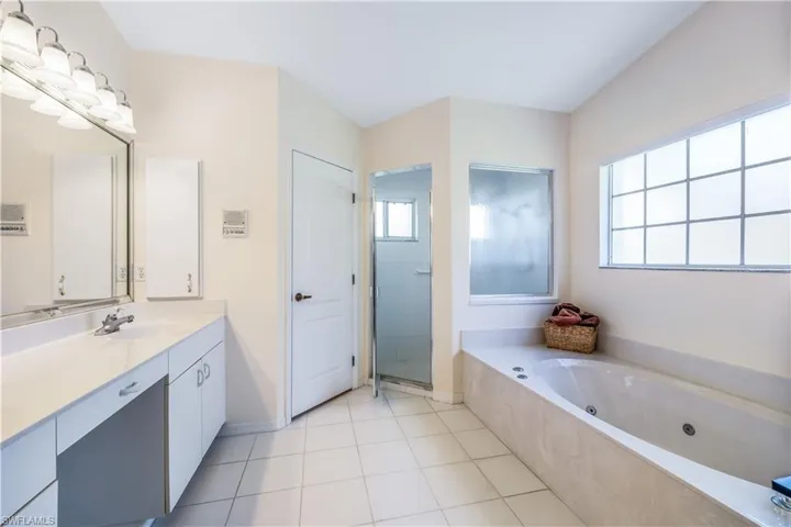 Primary Bathroom featuring shower with separate bathtub, vanity, and tile flooring